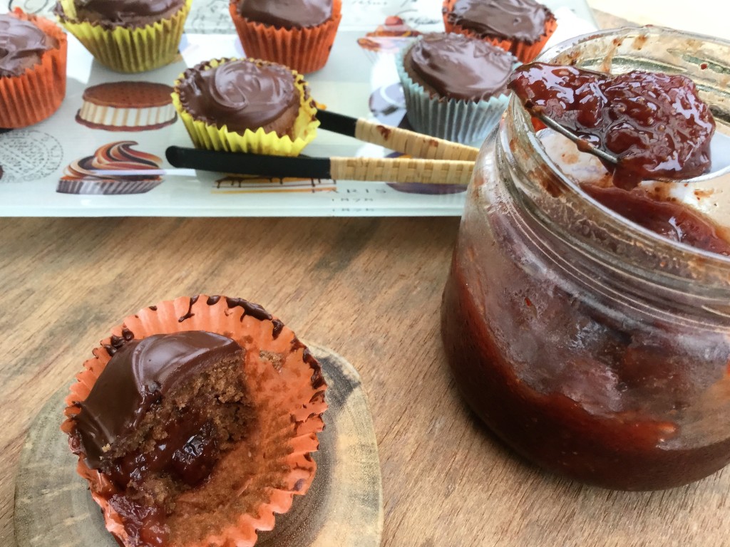 Chocolate cupcakes jam filled with jam jar and spoon